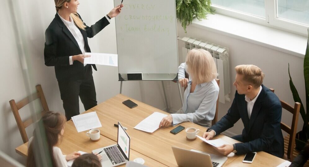 businesswoman-leader-giving-presentation-explaining-team-goals-group-meeting_1163-4879